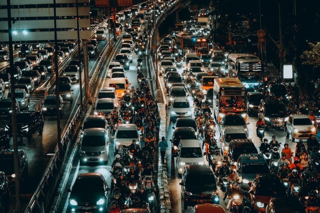Dense nighttime traffic jam in Jakarta with cars and motorcycles filling the busy streets.