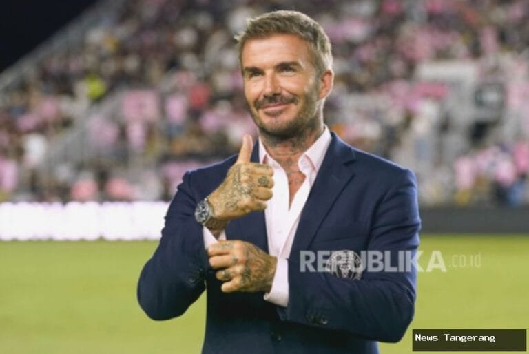 David Beckham tersenyum dan mengacungkan jempol setelah menerima gelar kebangsawanan.