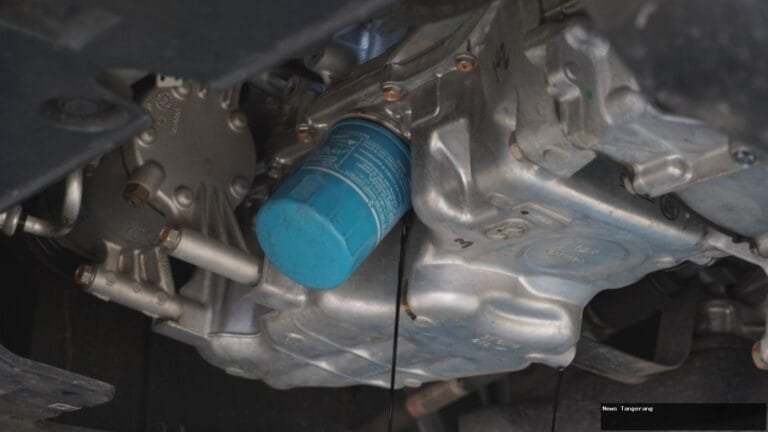 Filter oli biru terpasang pada mesin mobil, menyaring kotoran untuk performa optimal.