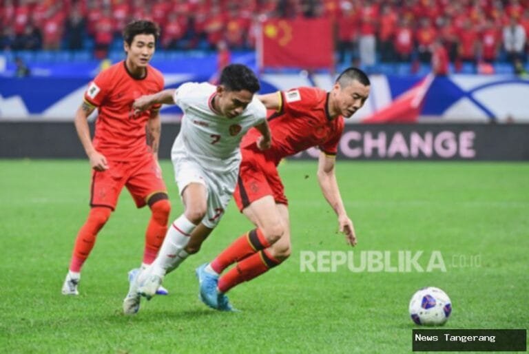 Duel pemain Indonesia dan China dalam pertandingan sepak bola di lapangan.