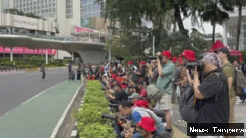 Deretan fotografer membidik pelari di jalanan Jakarta, memanfaatkan tren foto lari.