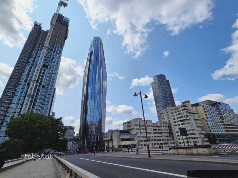 Pemandangan kota London dengan gedung-gedung tinggi dan langit biru berawan.