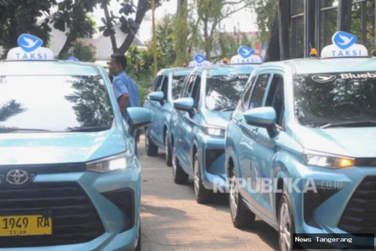 Jajaran taksi Blue Bird berwarna biru muda dengan logo burung di atasnya.
