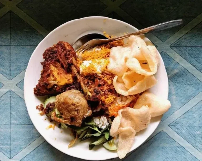 Sepiring nasi uduk dengan ayam goreng, perkedel, kerupuk, dan lalapan di Jakarta.