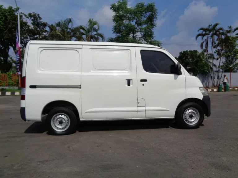 Daihatsu Gran Max Blind Van putih tampak samping, meluncur di Jakarta.