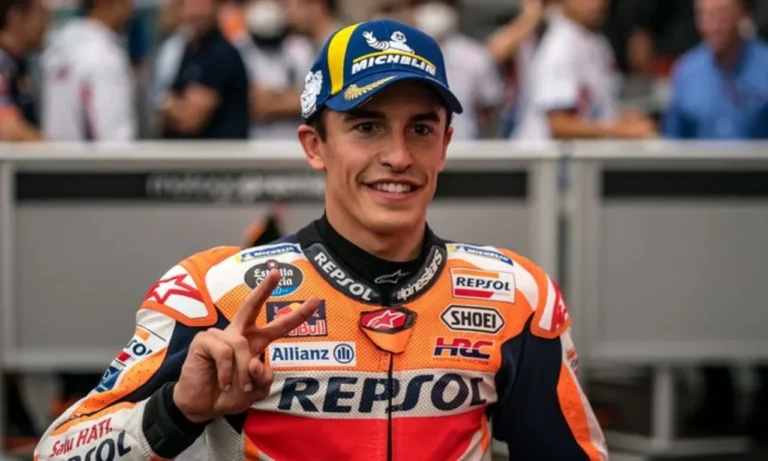 Marc Marquez tersenyum dengan gestur dua jari, merayakan gelar juara dunia ketujuh.
