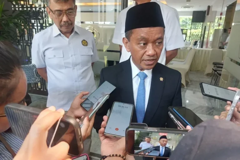 Seorang pria berkemeja jas hitam diwawancarai oleh sejumlah jurnalis dengan ponsel.