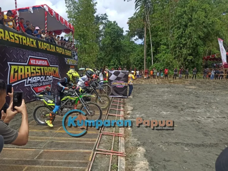 Pembalap bersiap di garis start Kejuaraan Grasstrack sebelum melaju di lintasan berlumpur.