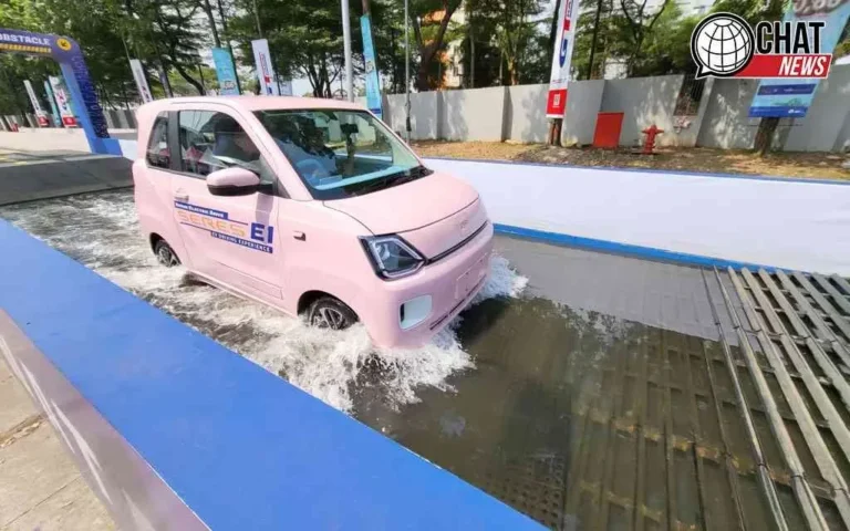 Mobil listrik berwarna pink melaju di genangan air, uji ketahanan.