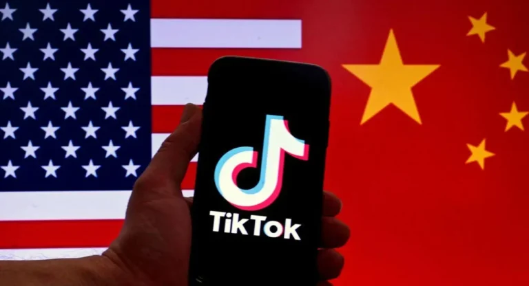 Ponsel menampilkan logo TikTok, latar bendera AS dan China, menandakan negosiasi.