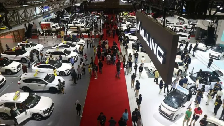Suasana ramai pengunjung di pameran otomotif IMOS, deretan mobil dan motor dipajang.