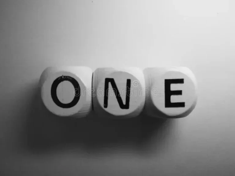 Tiga buah dadu kayu bertuliskan "ONE" dengan huruf kapital berwarna hitam.