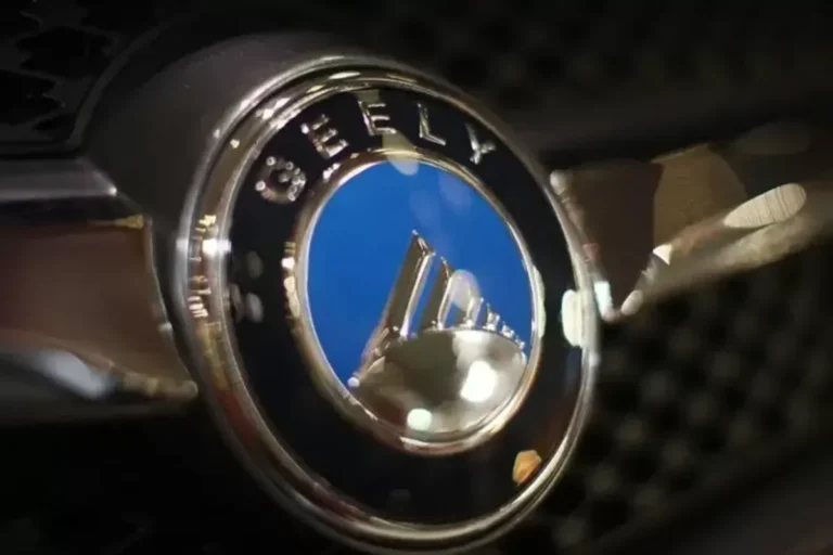 Logo Geely Auto berwarna perak dan biru, menandai produksi lokal di Indonesia.