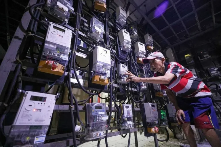 Pria memeriksa deretan meteran listrik PLN; tarif listrik dipastikan stabil hingga akhir 2025.