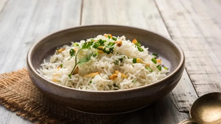 Semangkuk nasi daun jeruk dengan taburan bawang goreng dan irisan daun bawang.
