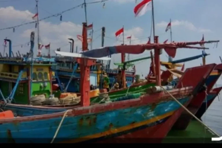 Deretan perahu nelayan tradisional Indonesia dengan bendera merah putih berkibar.
