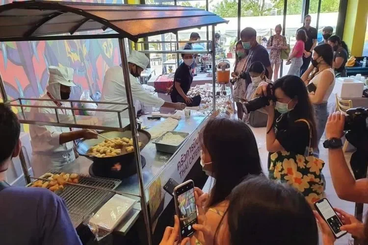 Gerai gorengan ramai pengunjung yang merekam proses pembuatan.