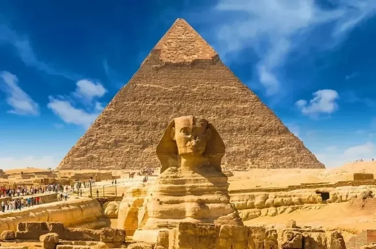 Piramida Giza dan Sphinx ikonik di Mesir dengan langit biru cerah.