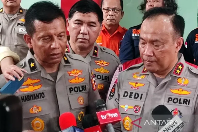 Beberapa perwira polisi di depan mikrofon, fokus ke detail seragam dan pangkat.