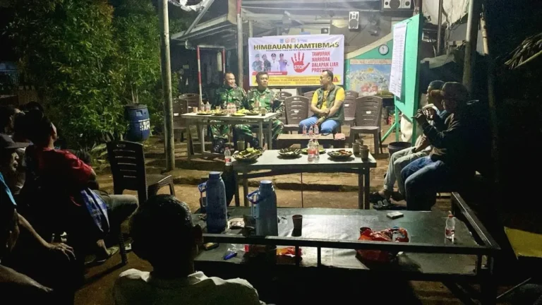 Koramil Serpong dan warga duduk bersama membahas Siskamling di malam hari.