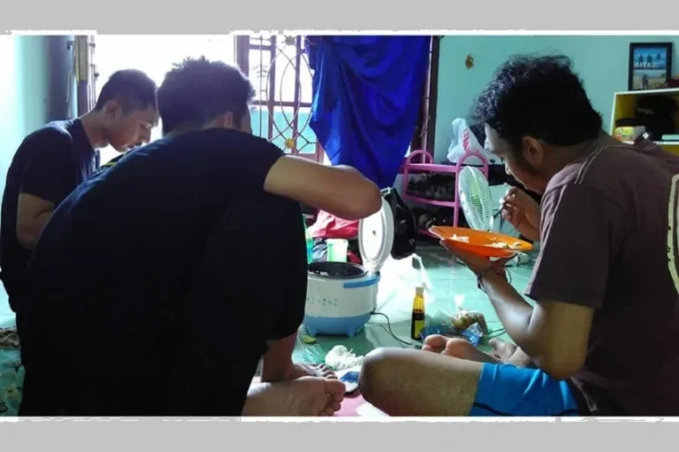 Mahasiswa makan bersama nasi dari rice cooker di kamar kos sederhana.