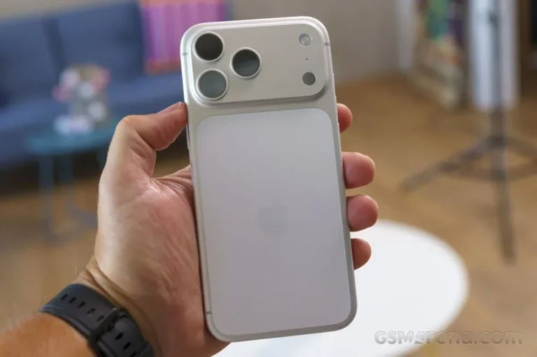 Tangan memegang iPhone 17 Pro warna perak dengan desain unibody aluminium dan modul tiga kamera belakang.