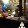 Dua pria menikmati wedang ronde di warung kaki lima pada malam hari.
