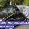 Mobil hitam dengan kaca depan pecah, diduga milik Lurah Manggarai Selatan usai diamuk massa.