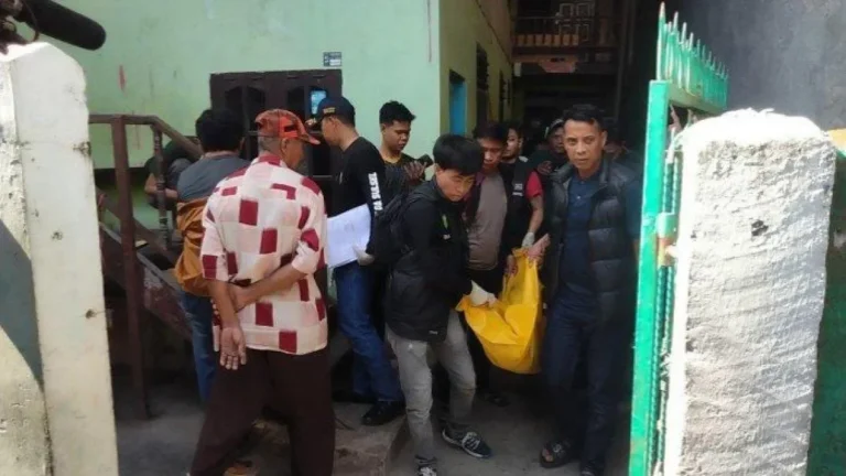Petugas mengevakuasi jenazah terbungkus kantong kuning dari sebuah bangunan di lokasi kejadian.