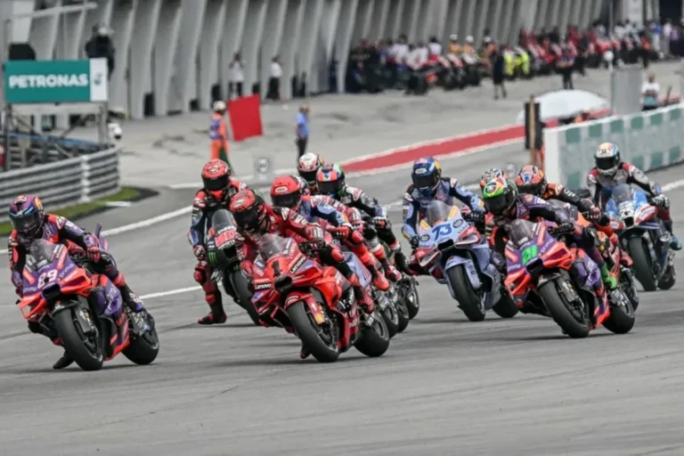 Beberapa pembalap MotoGP saling bersaing ketat saat berbelok di tikungan lintasan balap.