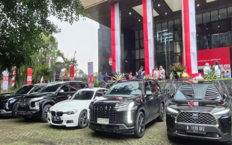 Deretan mobil mewah dan SUV terparkir rapi di depan gedung berhias merah putih.