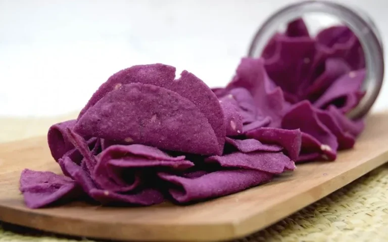 Camilan keripik ungu rasa keju khas Hokkaido berhamburan dari toples di atas talenan kayu.