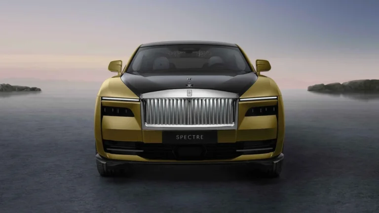 Tampilan depan mobil listrik mewah Rolls-Royce Spectre dua warna emas dan hitam.