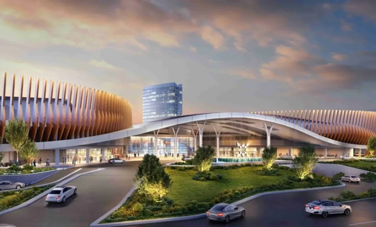 Rendering megah fasilitas modern dengan arsitektur melengkung, area masuk mobil, dan bangunan tinggi.