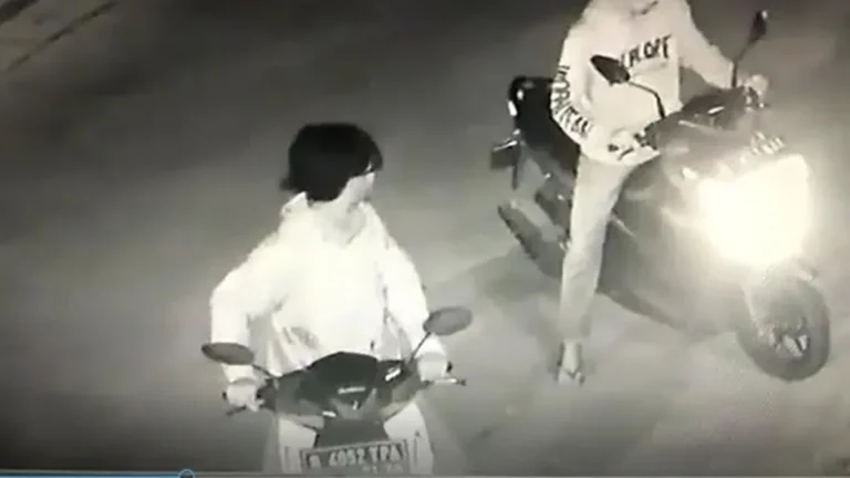 Rekaman CCTV menunjukkan dua terduga pelaku kejahatan berkendara sepeda motor pada malam hari.