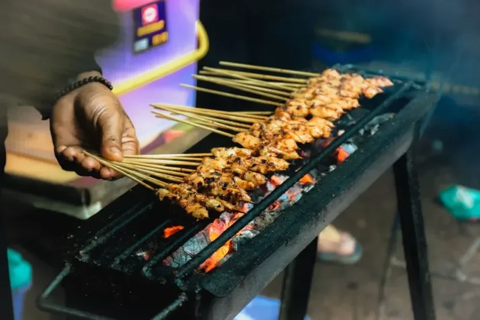 Close-up of chicken satay being grilled over charcoal in Jawa Barat, Indonesia.